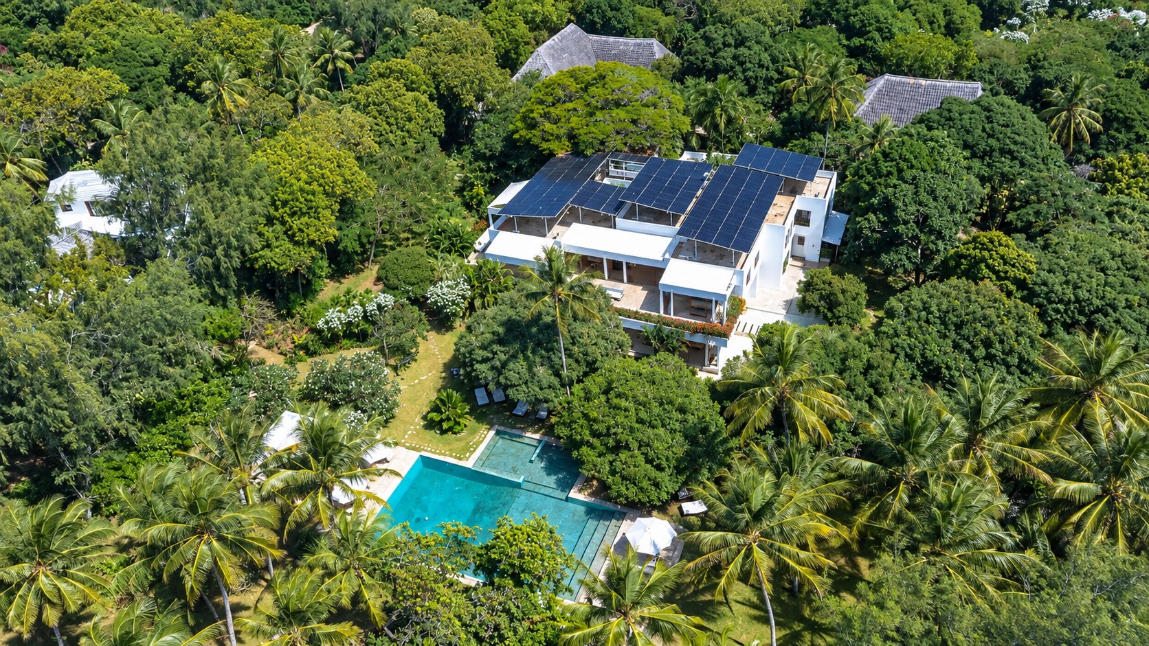 Aerial view of Zuri — the white villa, pool and gardens among the palms at Garoda Beach